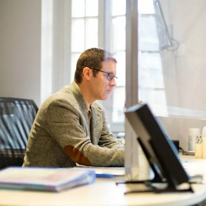 Conseiller funéraire en costume travaillant sur un ordinateur au bureau.