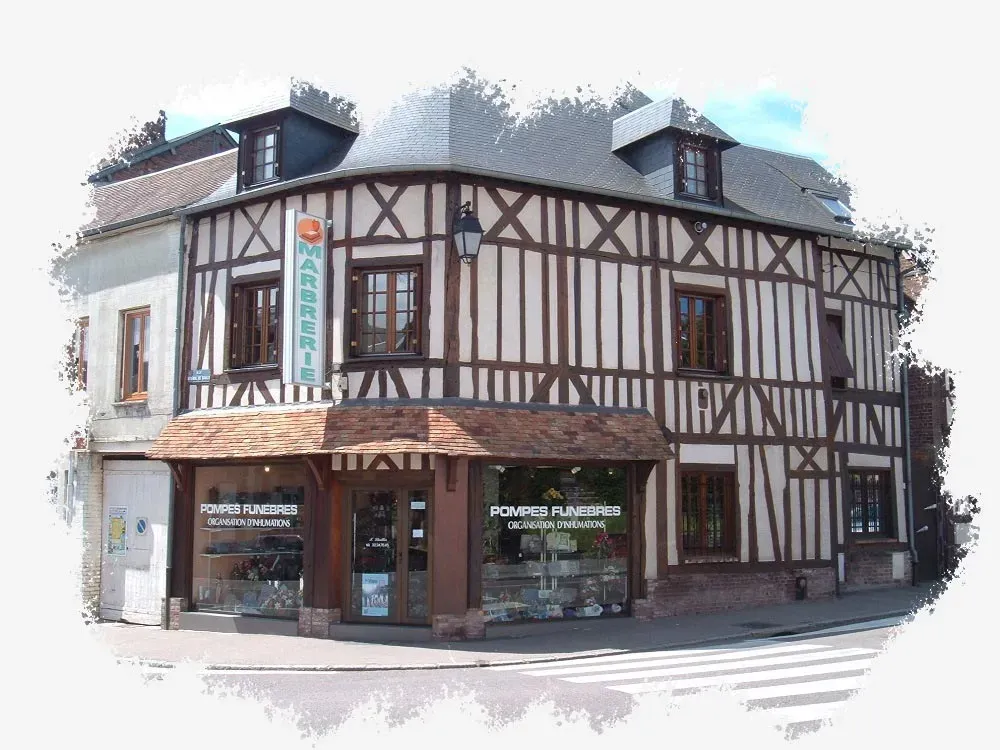 Façade détourée en briques et colombages de la Marbrerie Pompes Funèbres Lhuillier au Neubourg.